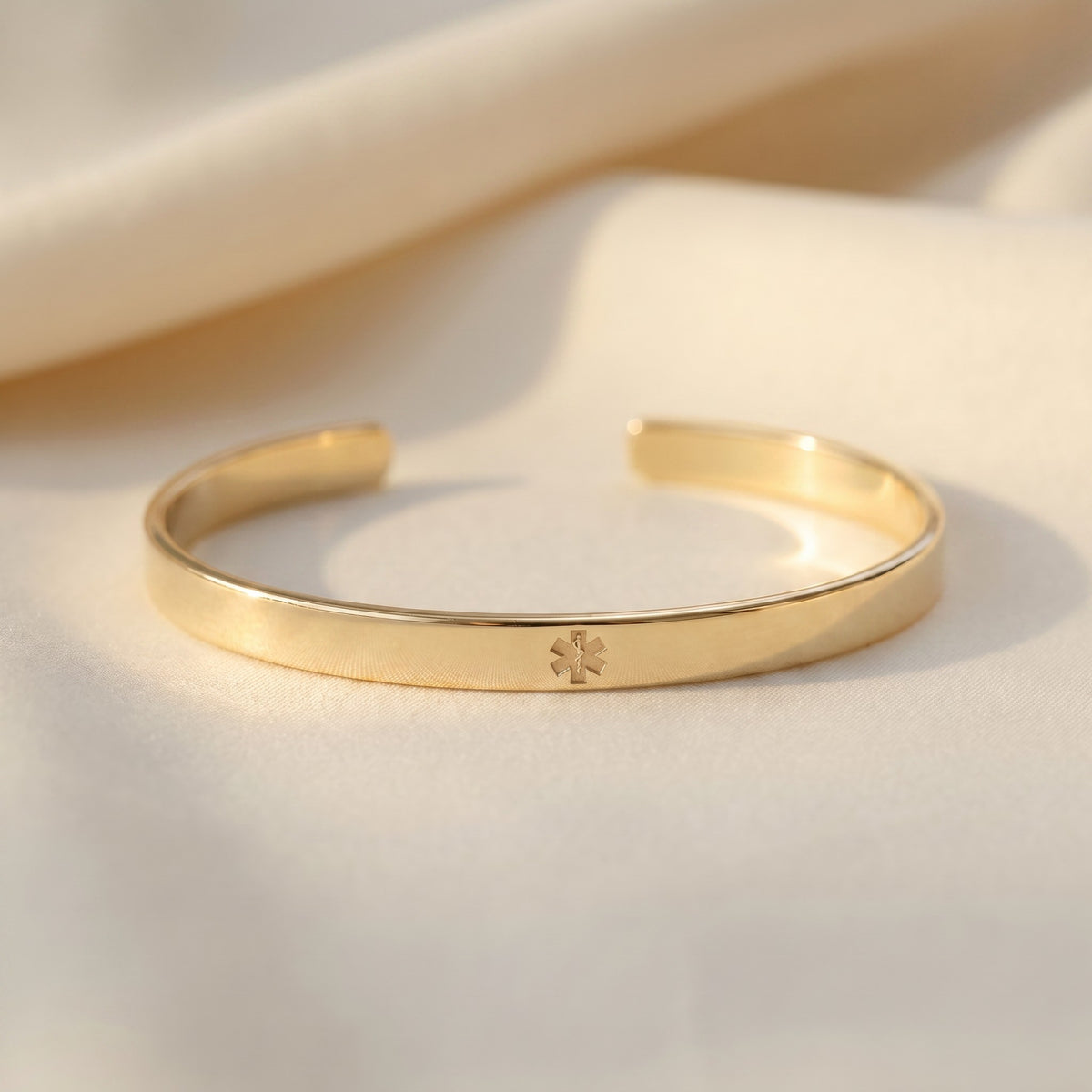 gold bracelet with medical symbol on the outside